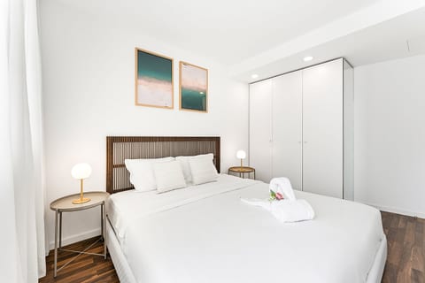 Bright minimalist bedroom with crisp linens and spacious wardrobe