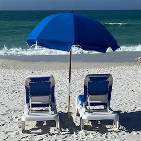 Beachfront relaxation with lounge chairs, umbrella, and ocean views