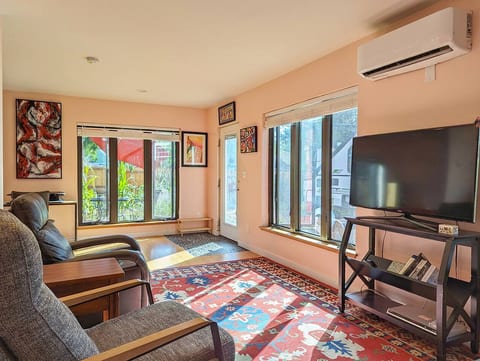 Movie nights feel extra cozy with plush chairs and a rug that warms the room with personality.