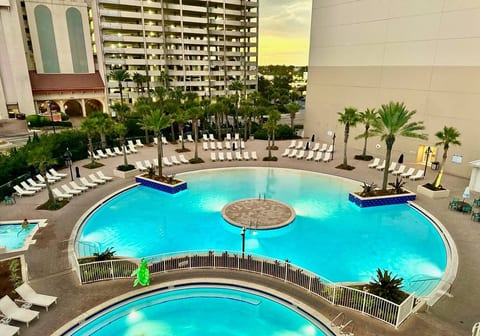 Enjoy the breathtaking lagoon-style pool with plenty of seating, palm-lined walkways, and a serene evening ambiance