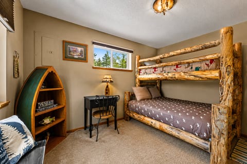 Rustic bunk room with log beds, natural light, and charming cabin touches