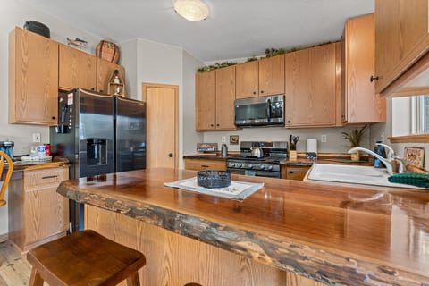 Cozy cabin kitchen with live-edge island, gas range & seating