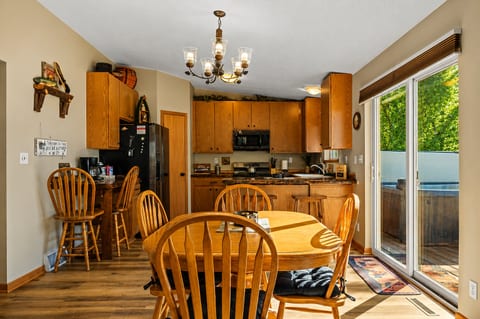 Sunny dining area with full kitchen and deck access to the hot tub