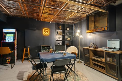 Our favorite space in the house features an arcade, a record player, cards, a poker set, and various games, all complemented by a bartender kit and glassware for a complete entertainment experience.
