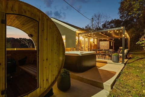 Gather, sip, and relax after a day on the Bourbon Trail—the covered deck features cozy seating around the fire, an outdoor dining area, a bubbling hot tub, and a barrel sauna made for unwinding in good company.