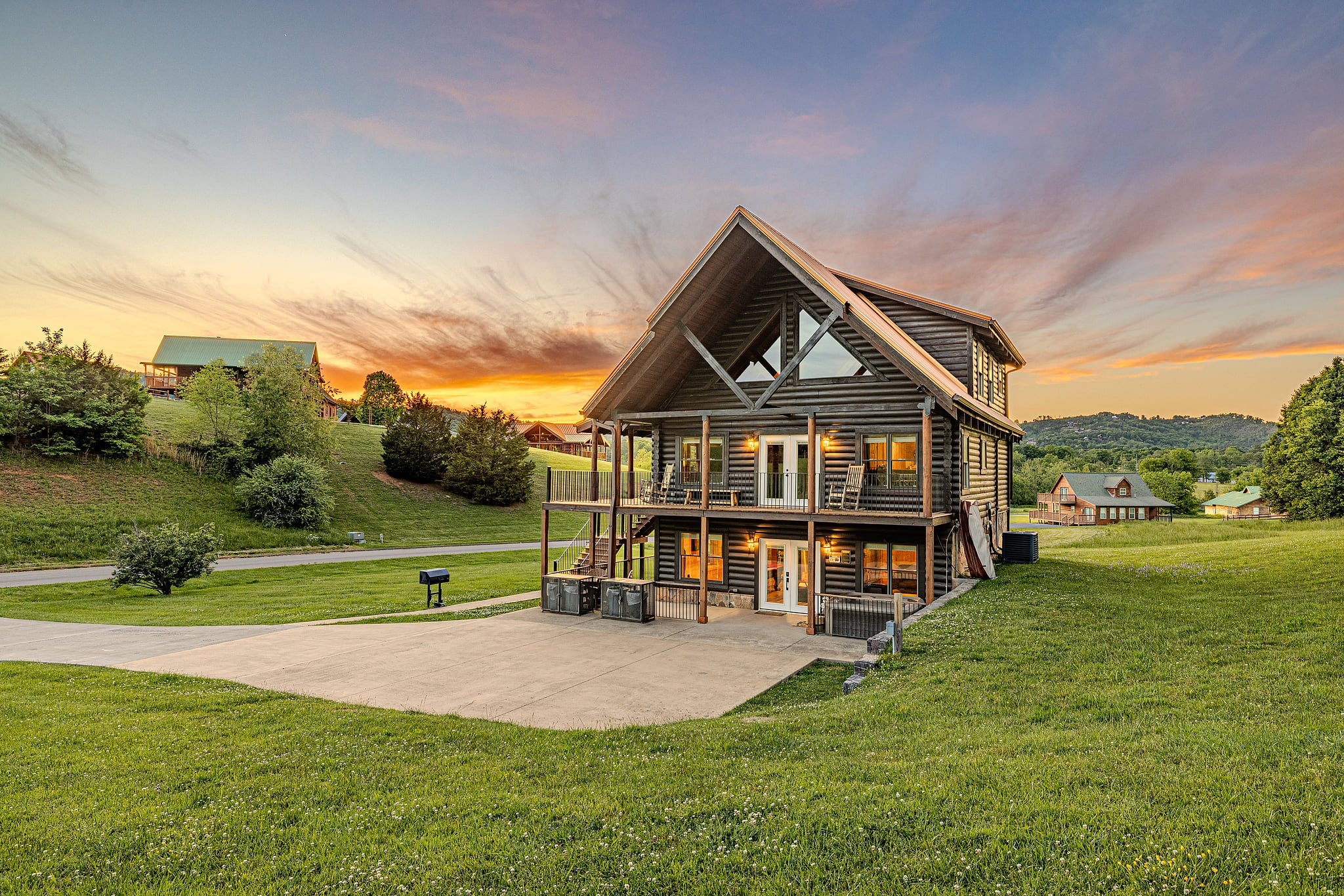 Modern multi-level cabin with decks, sunset views, and wide-open lawn