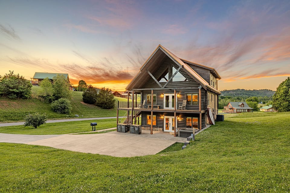Modern multi-level cabin with decks, sunset views, and wide-open lawn
