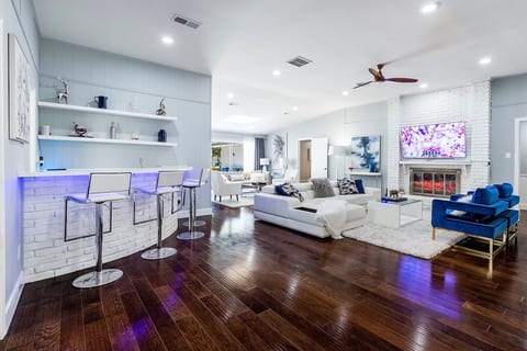 The open concept, with 2 living room spaces, a bar, and formal dining, is excellent for entertaining.