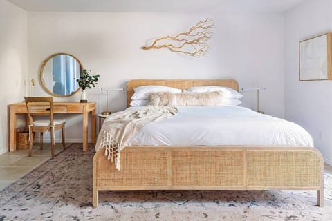 The natural elements of the primary bedroom bring tranquility to your stay.
The king-sized bed is made from rattan and a solid mango tree frame and the bed features soft Brooklinen sheets.
Each bedroom provides a dedicated space to work.