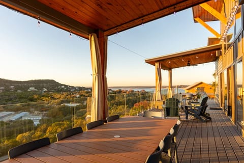 Expansive covered deck with breathtaking lake views and double outdoor dining tables, seating 20+ guests-- perfect for group meals, sunset cocktails, and unforgettable gatherings. 