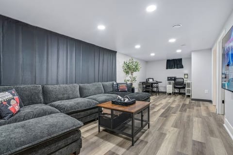 Family room with large couch, TV, desk, games