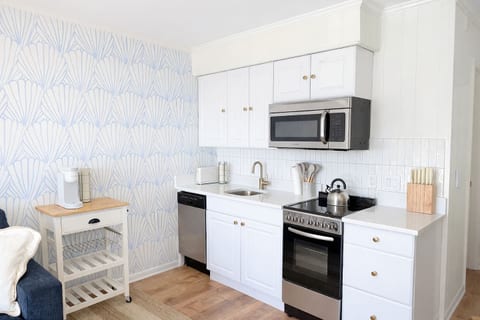 A bright, coastal kitchen with quartz countertops, stainless steel appliances, and everything you need for easy vacation meals.
