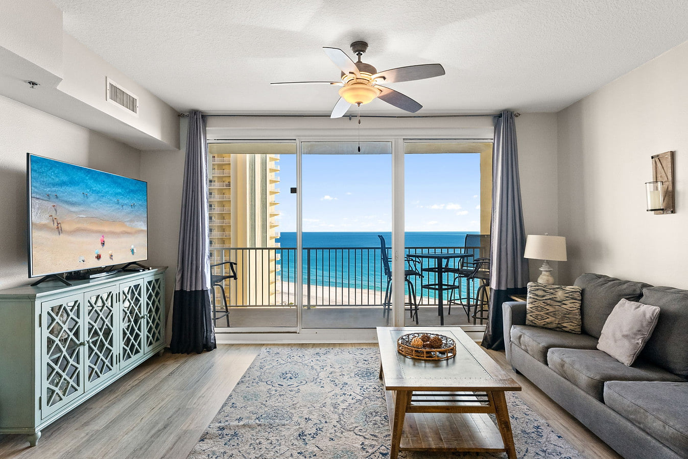 Comfortable Gulf-view living room with a queen-size sleeper sofa and private balcony access overlooking the water.