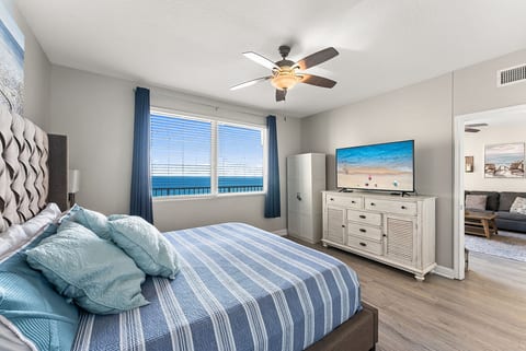 Comfortable king bedroom with TV and Gulf views for a peaceful retreat.