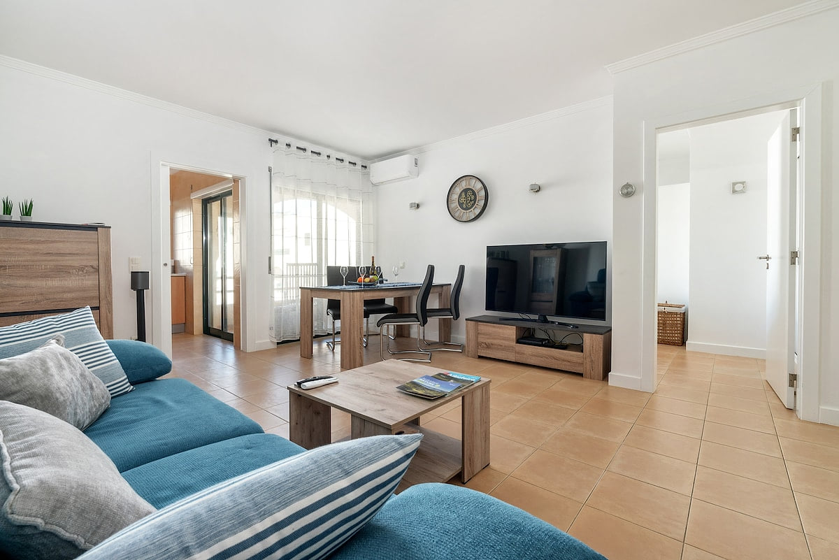 A comfortable seating area with a cozy sofa, TV and dining table.