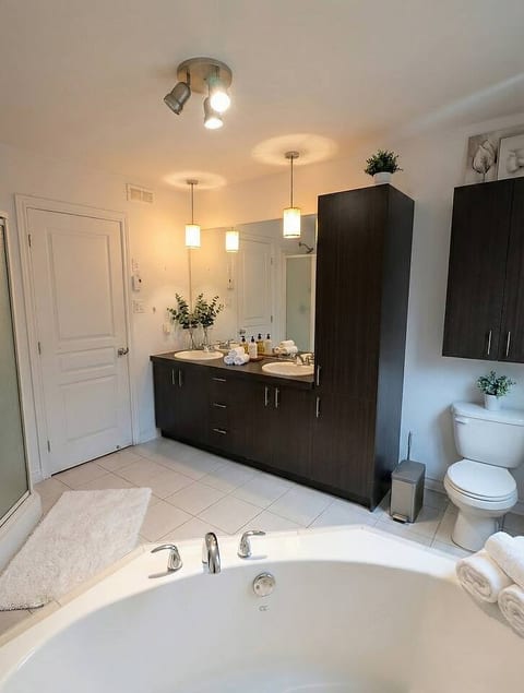 Refresh in this spacious bathroom, complete with a large double vanity for ample space and a luxurious corner jacuzzi tub for ultimate relaxation.