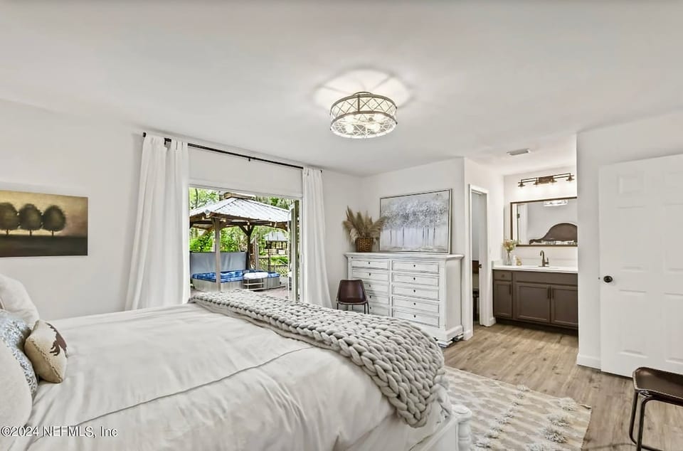 King bedroom with private bathroom opens up to the wide back deck with loungers and adult hot tub! Includes a large walk in closet.