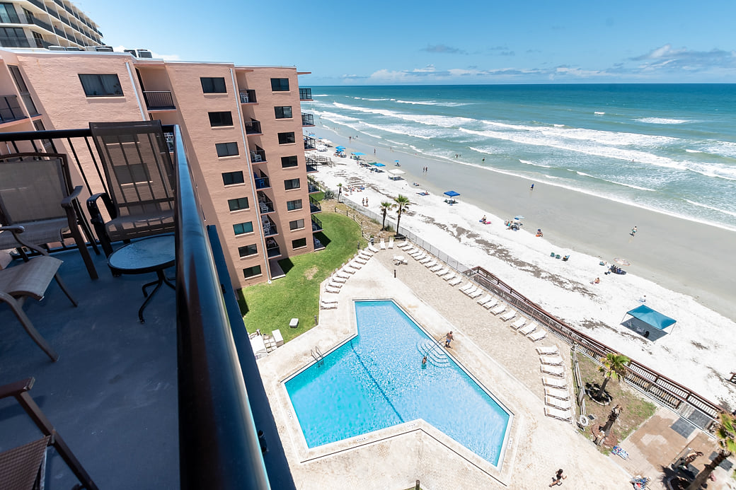 Balcony overlooks pool and ocean