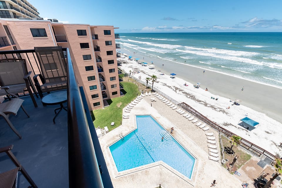 Balcony overlooks pool and ocean