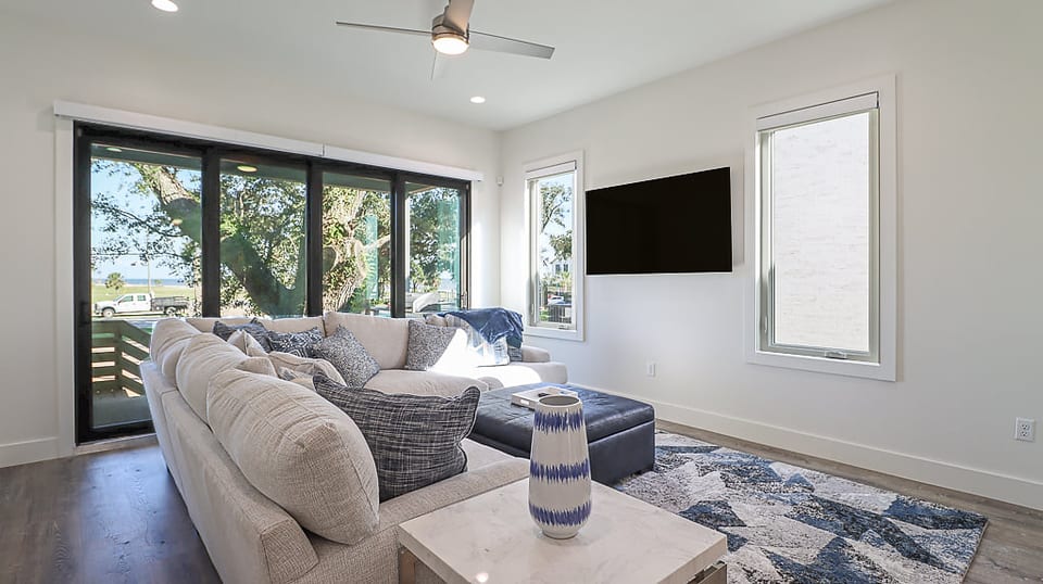 Luxurious and Modern Beach House Living Room with Doors Leading Out Toward the Beach