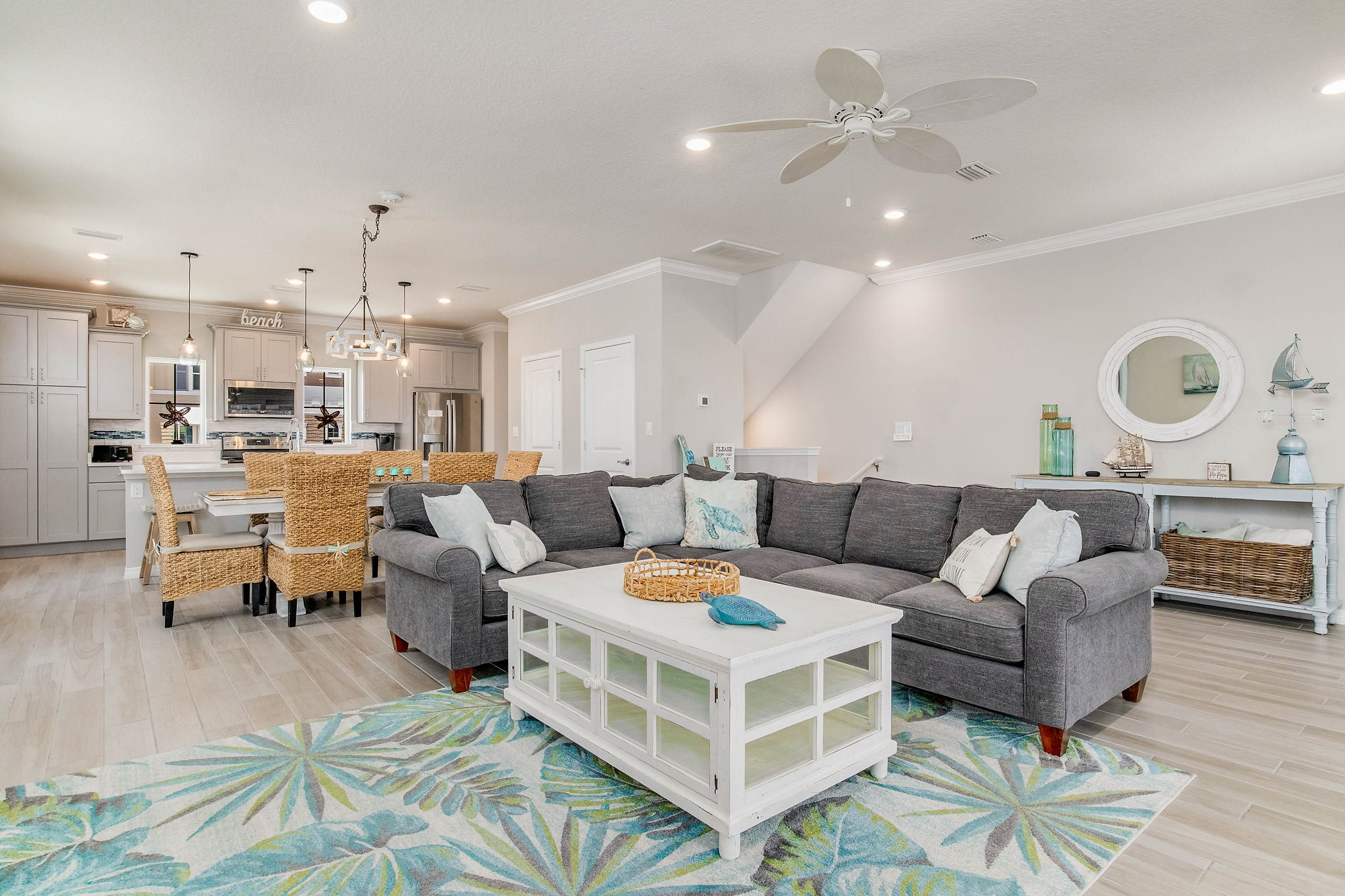 Open-concept living room with L-shaped sectional and balcony access at Lost Key townhome