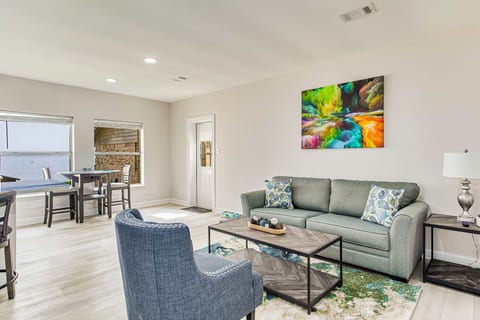 Open-concept living room with cozy furniture with sleeper sofa and bay views at Gulf Breeze waterfront house near Pensacola