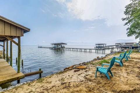 Turquoise Adirondack chairs overlooking the bay at Gulf Breeze bayfront vacation rental