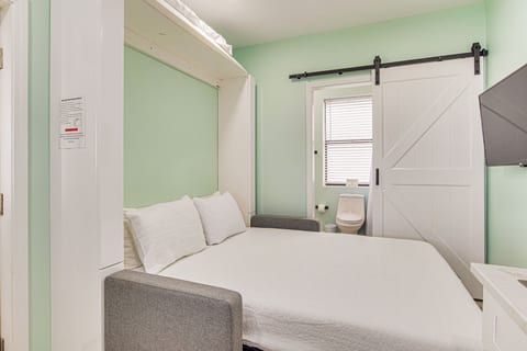 Comfortable murphy bed extended with flat screen TV with private bathroom showing