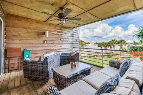 Covered balcony with wicker furniture and Intracoastal views at Needle Rush Poin