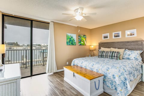 Primary Bedroom features King bed with comfortable linens, ensuite bathroom with tub/shower combination, and beautiful Old River and Ono Island bay views through large windows.