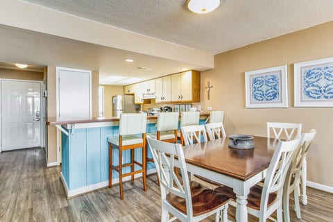 Open-concept dining with comfortable seating for 6 and stunning Old River views at Wind Drift Orange Beach bayfront condo