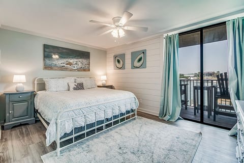 Primary bedroom with king bed and TV at Wind Drift Orange Beach waterfront vacation property