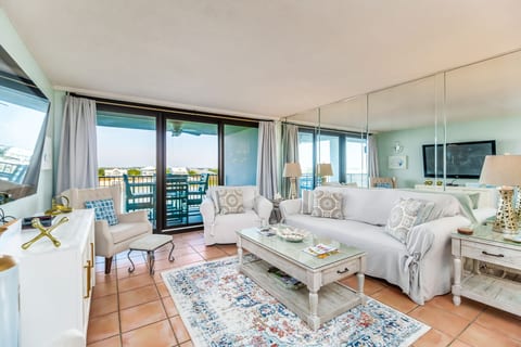 Open-concept living room with comfortable seating and stunning Old River views at Wind Drift Orange Beach bayfront condo