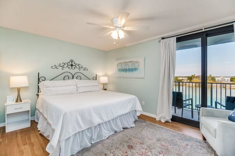 Primary Bedroom features King bed with comfortable linens, ensuite bathroom with tub/shower combination, and beautiful Old River and Ono Island bay views through large windows.