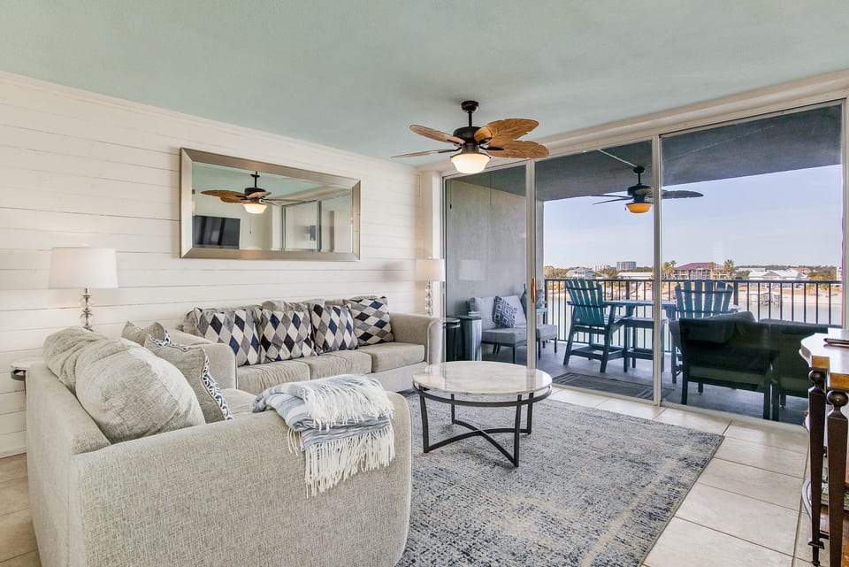 Open-concept living room with comfortable seating and stunning Old River views at Wind Drift Orange Beach bayfront condo