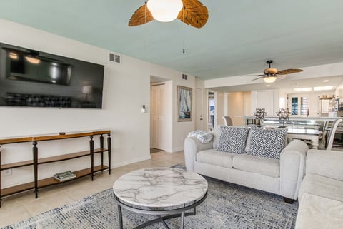 Open-concept living room with comfortable seating and stunning Old River views at Wind Drift Orange Beach bayfront condo with queen sleeper sofa