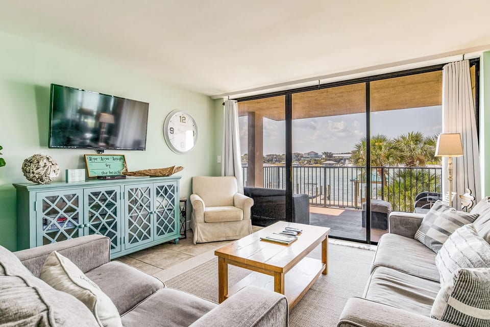 Coastal living area with flat-screen TV and sliding glass doors to patio overlooking Old River Orange Beach Alabama

