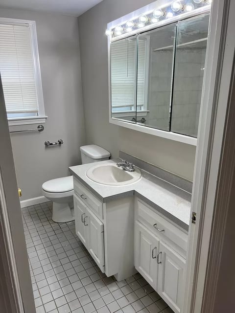 Bright, clean bath with storage, lighted mirror, and tub/shower combo