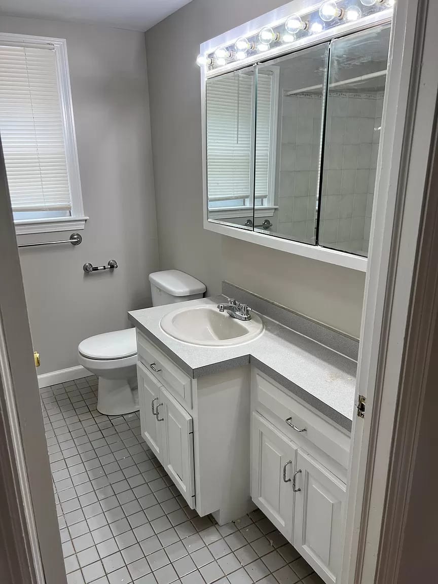 Bright, clean bath with storage, lighted mirror, and tub/shower combo