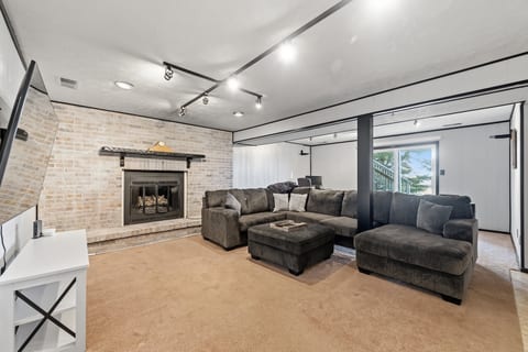 Cozy lounge with oversized sectional, fireplace, and bright walkout access
