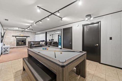 Spacious game room with pool table, fireplace, and cozy lounge seating