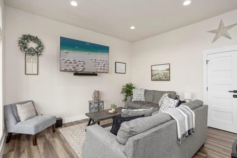 Bright lounge with big-screen TV, plush sectional, and chic decor.