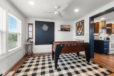 Game Room with full-sized foosball table, regulation dart board, and smart TV.