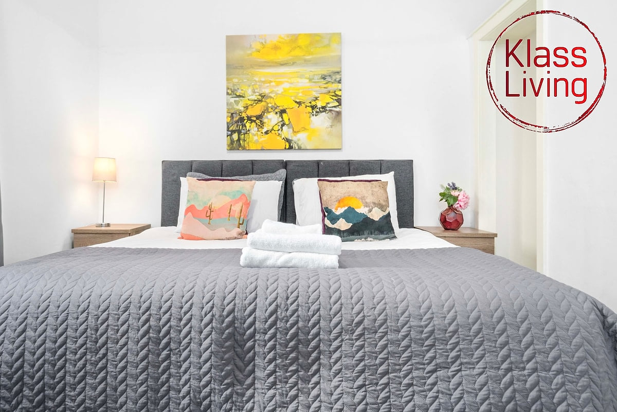 Spacious bedroom one at Klass Living Short Lets & Serviced Accommodation Airdrie, featuring a super king bed that can be converted into two singles for flexible sleeping arrangements.