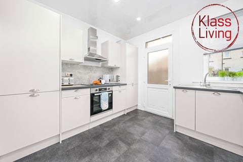 Modern fully equipped kitchen At Klass Living Short Lets & Serviced Accommodation Airdrie with oven, hob, microwave, kettle, toaster & cookware. Everything you need to prepare meals during your stay.