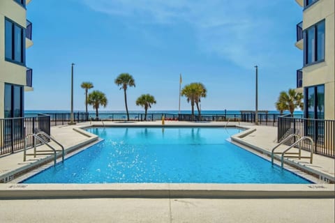 Enjoy the oceanfront pool with palm-lined views and sparkling Gulf waters just beyond the deck.