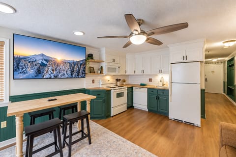 Enjoy the warmth of the fireplace and the convenience of a well-equipped kitchen in this inviting open-concept space.