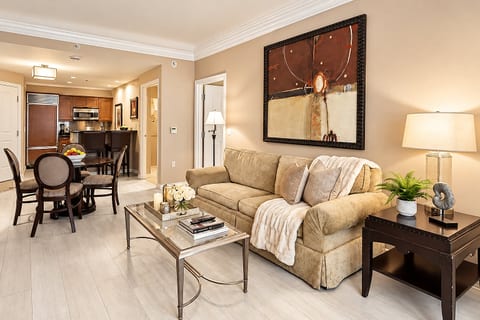 Inviting Living Room — Plush seating, refined furnishings, warm lighting, and an open dining and kitchen connection create an elegant home-away-from-home setting.