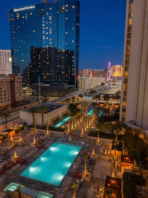 The pool after dark at MGM Signature. Turquoise water, lit palms, the Strip glowing past the deck. Cabana afternoons, late-light swims, the monorail humming overhead.

Plan the stay.