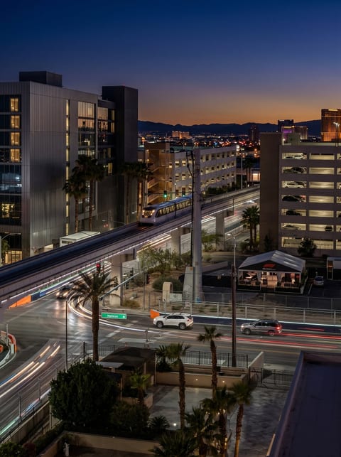 Harmon Avenue at night, the F1 corridor lit below the window. MGM Signature puts you on the race line and a short walk from the Strip.